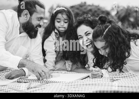 Glückliche indische Familie, die Spaß beim Spielen mit Kindern im Freien im Stadtpark hat - Sommerzeit und Elternschaftskonzept - Hauptfokus auf Vaterhand Stockfoto