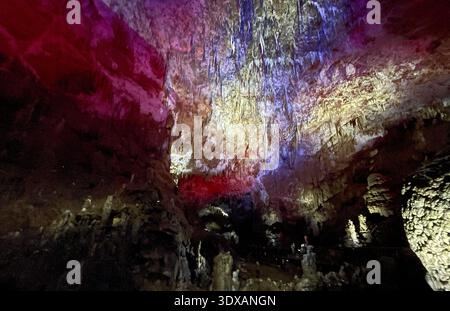 Farbenfrohe Höhle mit glitzernden, bunten Stalaktiten und Stalagmiten. Coole magische Fantasy unterirdischer Wunderland Hintergrund Stockfoto