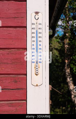 Kvikkjokk, Schweden - 21. Juli 2024: Ein an der roten Holzwand der STF Kvikkjokk Fjallstation montiertes Außenthermometer zeigt die Durintemperatur an Stockfoto