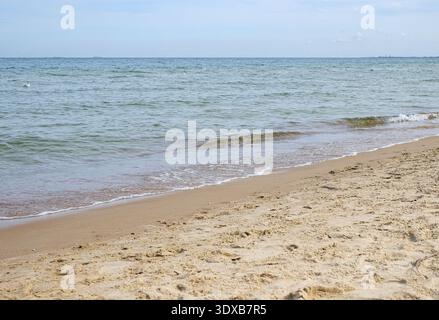 Eine ruhige horizontale Aufnahme eines Sandstrandes mit einer ruhigen ostsee und kleinen Wellen. Der Horizont ist klar und es gibt viel Kopierraum. natura Stockfoto