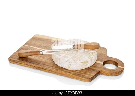 Brie Käse mit Küchenutensilien auf einem hölzernen Küchenbrett, isoliert auf weißem Hintergrund, Nahaufnahme Stockfoto