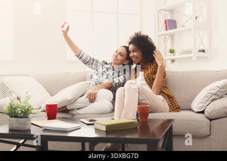 Zwei Freunde sitzen auf einer Couch in einem hellen Raum Stockfoto