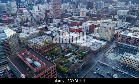 Aus der Vogelperspektive sehen Sie eine dichte Stadtlandschaft, in der Gebäude und Straßen zusammenfließen, und einen kleinen Park, der inmitten der architektonischen Vielfalt sichtbar ist, Portland, Orego Stockfoto