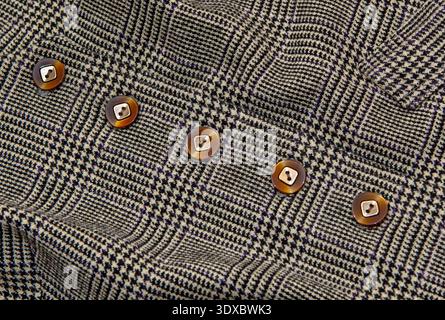 Knöpfe auf Stoff als Hintergrund. Klassisches Karomuster mit Knöpfen. Stockfoto