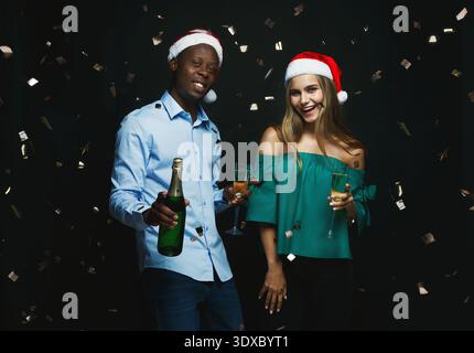 Feier mit Getränken während der Feiertagsparty in festlicher Umgebung mit Konfetti-Fall Stockfoto