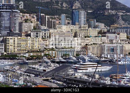 Panoramablick auf die Skyline von Monte Carlo Monaco, Port Herkules mit Superyachten und Hochhäusern vor felsigen Bergen. Monte Carlo, Monaco Stockfoto