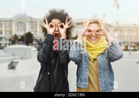 Zwei junge Frauen stehen zusammen in einem geschäftigen Stadtviertel Stockfoto