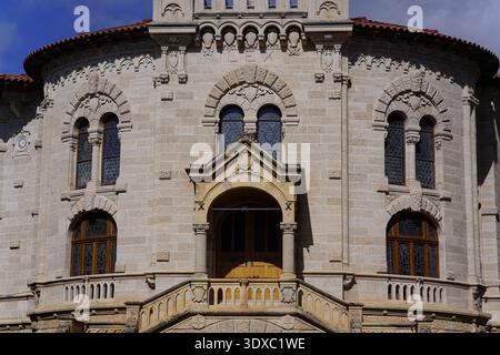 Fassade des Palais de Justice Monaco mit romanischen Steinbögen, verzierten Balkon und historischem Eingang unter blauem Himmel. Monte Carlo, Monaco Stockfoto