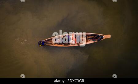 Aus der Vogelperspektive eines einsamen Kanus, das durch das trübe Wasser in der Nähe des Kofa Dam fährt, einer Szene der stillen Industrie und zeitloser Tradition, Suleja, Niger, Niger Stockfoto