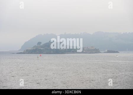 Boote fahren an einem trüben Tag in Devon, England, an Drake's Island im Plymouth Sound vorbei. Stockfoto