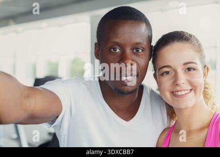Collage von zwei Menschen, die lächeln und ein Selfie in einem Fitnessstudio während des Tagestrainings machen Stockfoto