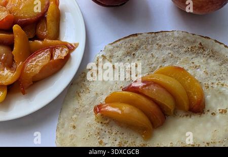Dünne Pfannkuchen mit Pfirsich. Draufsicht Stockfoto
