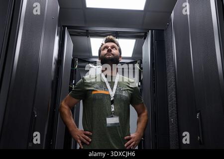Rechenzentrumstechniker inspizieren Server-Racks in einem modernen Rechenzentrum mit zuverlässigem professionellem Auftreten Stockfoto