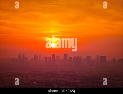 Sonnenuntergang über der Skyline von Dubai, Wolkenkratzer im warmen Abendlicht, urbane Landschaft, moderne Architektur. Drohnenansicht der Golden Hour aus der Luft Stockfoto
