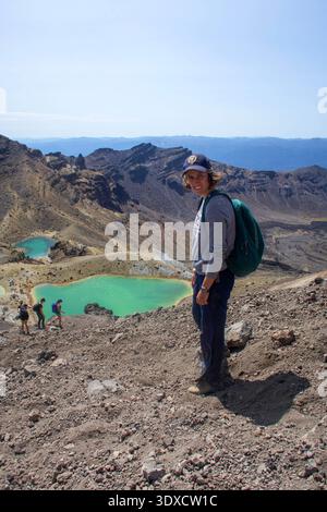 Wandererin mit Blick auf die Smaragdseen am Tongariro Alpine Crossing, Tongariro National Park, Nordinsel, Neuseeland. Stockfoto