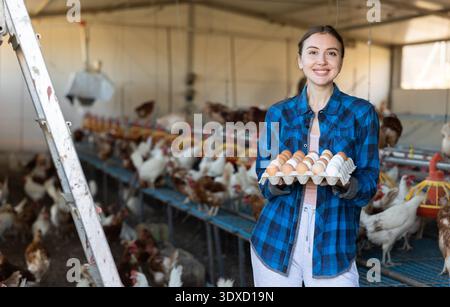 Porträt einer Bäuerin, die frische Eier in den Händen in einem Hühnerstall hält Stockfoto