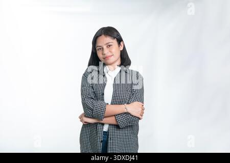 Porträt einer lächelnden jungen indonesischen Frau in einem karierten Hemd. Saubere Studioaufnahme für Lifestyle, junge Profis und lässige Modekonzepte. Stockfoto