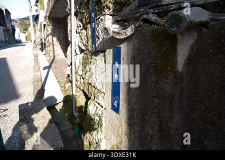 Blaue Straßenschilder an einer Steinmauer im historischen Viertel Teramachi, Nagasaki, Japan Stockfoto