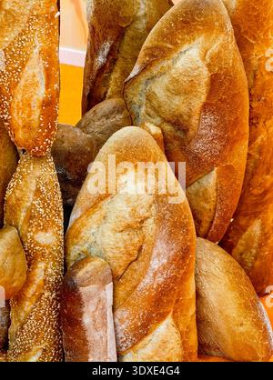 Köstliche Auswahl an frisch gebackenen Broten in einer verspielten Präsentation in einer Bäckerei an einem sonnigen Nachmittag Stockfoto