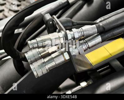 Hydraulikanschlüsse und -Schläuche an Maschinen zeigen technische Präzision und industrielle Funktionalität in einer Werkstatt Stockfoto