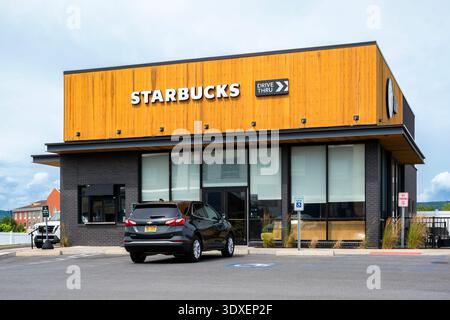 Utica, NY – 9. Juli 2025: Detaillierte Nahaufnahme des Starbucks Coffee-Shops und der Autos, die sich in Drive-Thru befinden Stockfoto