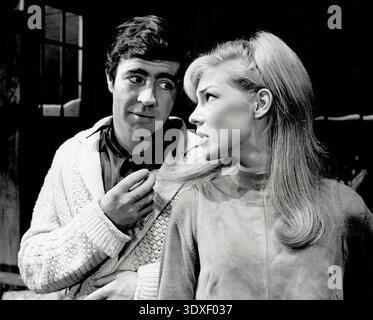Der britische Schauspieler Alan Bates und die US-amerikanische Schauspielerin Joanna Pettet sind hier auf einem Schwarzweiß-Werbefoto aus dem Jahr 1964 zu sehen. Die beiden treten tief in Konversation auf, möglicherweise während ihrer Aufführung im Broadway-Stück Poor Richard, das im selben Jahr eröffnet wurde. Stockfoto