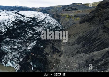 Luftaufnahme des starken Kontrastes zwischen dem Gletschereis und dem zerklüfteten Gelände, Mýrdalshreppur, Island. Stockfoto