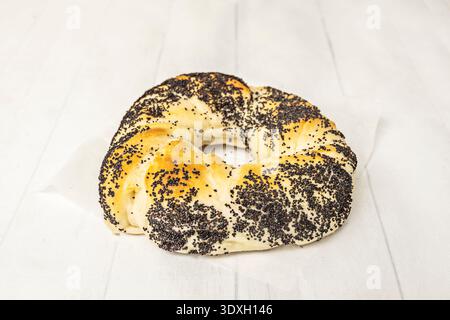 Ein verführerischer, vertikaler Stapel frisch gebackener Bagels: Herzhafte Knoblauch- und Zwiebelbagels am Boden, Seed Bagels in der Mitte Stockfoto