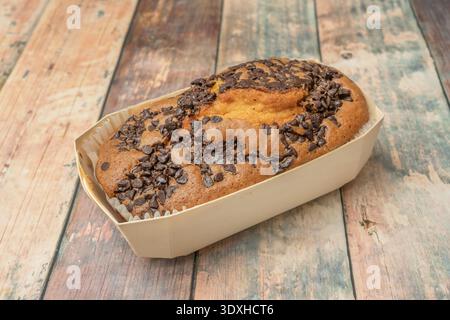 Ein Schokoladenschwammkuchen, gefüllt mit einer glatten Milchschokolade-Creme und bedeckt mit einer tiefen rubinroten Spiegelganache, die das Lichtspektakel reflektiert Stockfoto