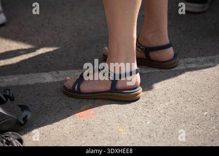 Frau in Sandalen mit Rückenriemen, die auf dem Markt laufen, lässiges urbanes Wandern Thailand, Fußhautstruktur, Blick aus einem hohen Winkel, auf dem Chatuchak Markt. Stockfoto