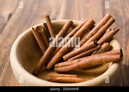 Zimtstangen in einer Holzschale auf Holztisch. Stockfoto