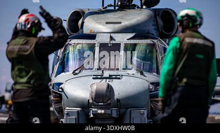 Ein U.S. Sailor signalisiert einen MH-60R Sea Hawk Helikopter, der an der Helicopter Maritime Strike Squadron 70 befestigt ist, auf dem Flugdeck des weltweit größten Flugzeugträgers, USS Gerald R. Ford (CVN 78), während er am 2. März 2026 zur Unterstützung der Operation Epic Fury im östlichen Mittelmeer eingesetzt wird. (Foto US Navy) Stockfoto