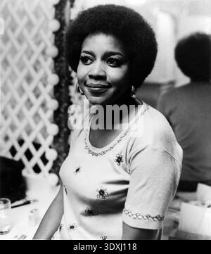 Dieses Schwarzweiß-Werbefoto aus dem Jahr 1971 zeigt die amerikanische Gospel- und R&B-Sängerin Mavis Staples, die für ihre kraftvollen Vocals und ihren Aktivismus bekannt ist. Sie wird sanft mit einem Afro-Hairstyle und Creolen in einem gestickten Oberteil gefangen. Stockfoto