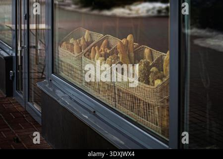 Verschiedene Brote und Baguettes in Korbkörben in der Bäckerei, traditionelle Konditorei Atmosphäre. Stockfoto
