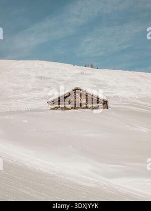 Einsames hölzernes Bergchalet auf dem schneebedeckten Hang in Verbier Stockfoto