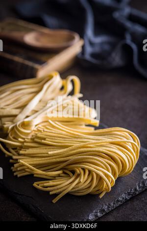 Bigolii-Nudelstränge ruhen auf einer weißen Oberfläche und wirken weich und frisch. Diese Art von Pasta wird oft in verschiedenen Gerichten verwendet. Stockfoto
