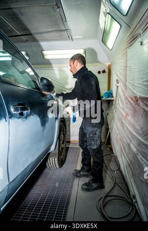 Karosserietechniker bereitet das Fahrzeug für die Lackierung vor Stockfoto