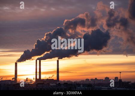 Rauch aus der Werkleitung des Heizwerks in der Stadt im Winter. Heizöl- oder Erdgaskraftwerk Stockfoto