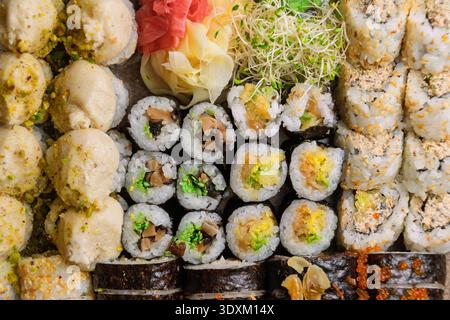 Verschiedene Sushi-Brötchen auf Holztablett. Vegane Sushi-Brötchen. Stockfoto