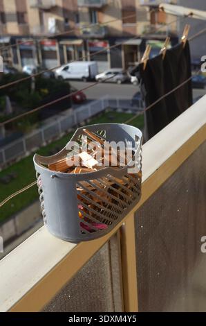 Korb mit Wäschespindeln auf einem Balkon Stockfoto