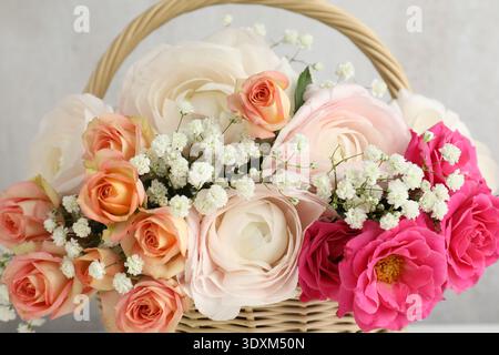 Schöne Blumen im Korb auf hellem Hintergrund, Nahaufnahme Stockfoto