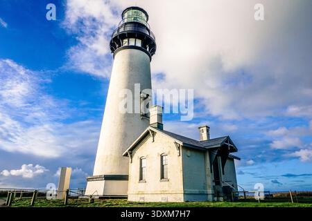 Ein Leuchtturm steht auf einem Hügel mit einem bewölkten Himmel im Hintergrund. Der Leuchtturm ist hoch und weiß und von Gras umgeben. Die Szene ist ruhig Stockfoto