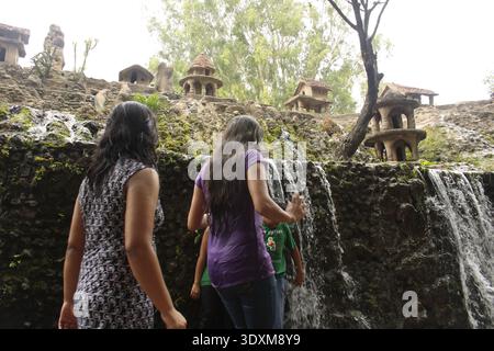 Zwei indische Mädchen nähern sich einem Wasserfall im Rock Garden in Chandigarh. Der Rock Garden ist ein Freilichtmuseum in der nordindischen Stadt. Stockfoto
