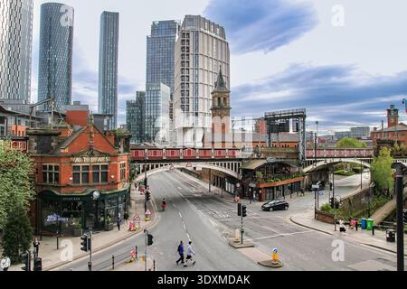 Skyline im Stadtzentrum von Manchester mit Eisenbahnviadukt und Atlas Bar in der Nähe von Deansgate Locks, modernen Wolkenkratzern und historischen Gebäuden. Stockfoto