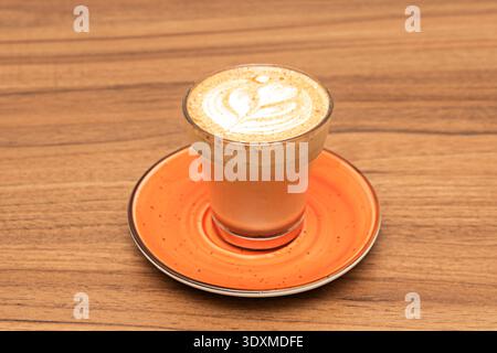 Ein intimes Detail des Schaums, bei dem die winzigen Bläschen der aufgeschäumten Milch eine cremige, dichte Schicht bilden, die sich nahtlos mit dem Kaffee am verbindet Stockfoto