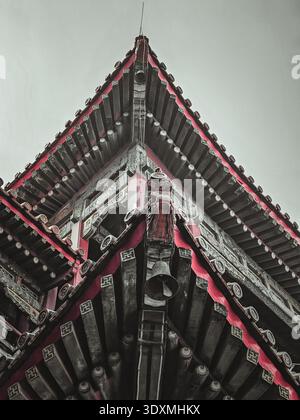 Eine detailreiche, hochwinklige Aufnahme erfasst das komplexe architektonische Design eines traditionellen chinesischen Tempeldaches in Peking, China. Stockfoto
