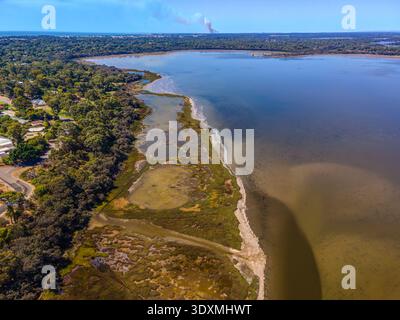 Ein Blick aus der Luft auf eine verwinkelte Mündung und Gezeitenebenen treffen auf ruhiges, flaches Wasser. Eine schmale Sandgrube und Flecken von Sumpfgebieten und Teichen verlaufen entlang Stockfoto