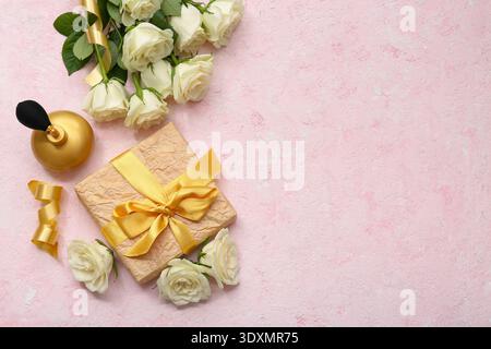 Komposition mit Geschenkbox, weißen Rosenblüten und Flasche Parfüm auf rosa Grunge Hintergrund Stockfoto