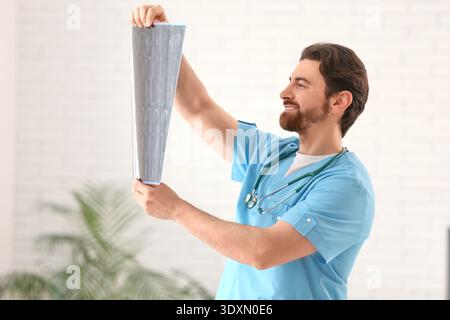 Gutaussehender Arzt, der MRT in der Klinik studiert Stockfoto
