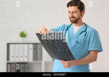 Gutaussehender Arzt, der MRT in der Klinik studiert Stockfoto